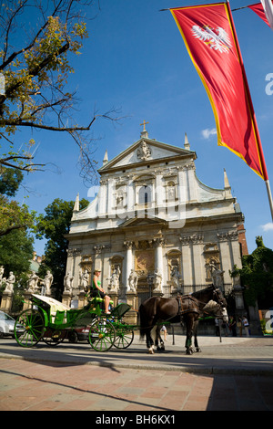 Tourist horse & carriage in front church of St. Peter and Paul, with 12 statues of the apostles guarding it. Krakow, Poland. Stock Photo