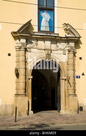 Photographic image of Pope John - Paul II on display in a window above an entrance of the Archbishop's Palace. Krakow, Poland. Stock Photo
