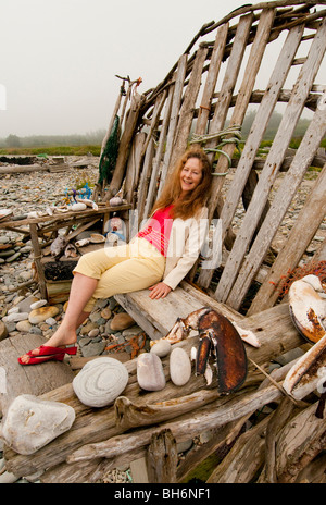 Nova Scotia, Yarmouth Bay, Woman relaxing on rustic wooden beach chair, Stanlely's Lobster Pound Stock Photo