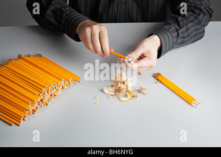 A man sharpening a heap of pencils Stock Photo