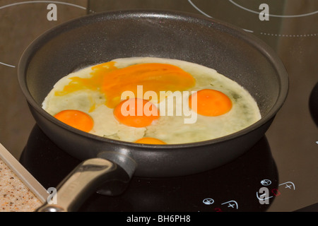 Eggs in frying pan. Five fresh eggs in a frying pan. One yolk is broken. Stock Photo
