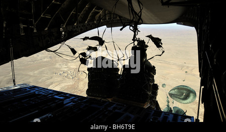 Container Delivery System bundles exit a C-17 Globemaster III during an airdrop mission. Stock Photo