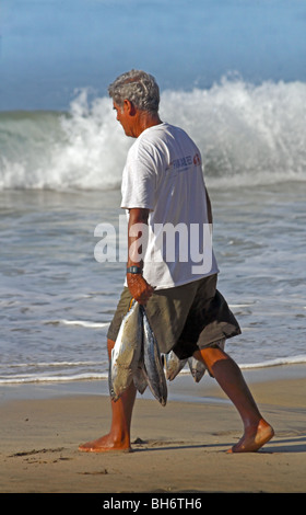 Puerto Escondido Oaxaca Mexico, man with fish on beach Stock Photo