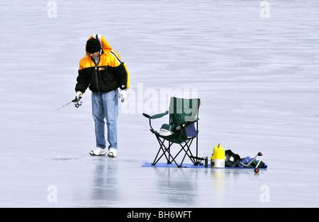 Man ice fishing on a frozen lake. Devils lake in North Dakota in the winter  at sunset Stock Photo - Alamy