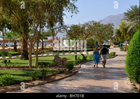 Guests holding hands walking through gardens 'Hilton Nuweiba Coral Resort', Nuweiba, Sinai, Egypt Stock Photo