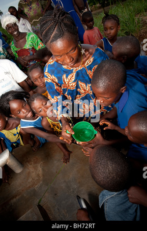 Children drinking water at village Ngo town Sierra Leone Stock Photo