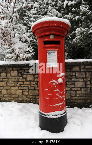 Red mailbox in the snow England Uk Stock Photo