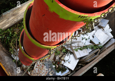 Builders' rubble chute from scaffolding into skip, UK Stock Photo