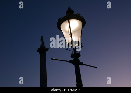 Ornamental lamp lit at dusk at Trafalgar Square London Stock Photo