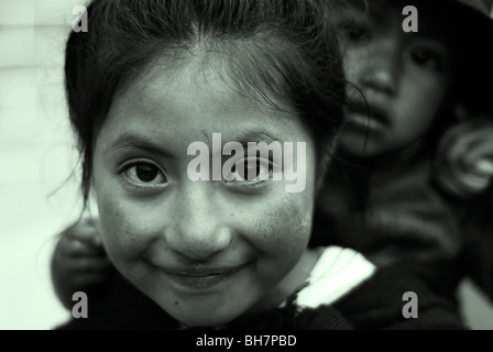 Ecuador, Latacunga, close-up of a girl looking away with her big bright brown eyes and smiling, her cheeks burnt by the sun, her Stock Photo