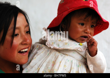 Ecuador, Latacunga, close-up of a girl looking away with her big bright brown eyes and smiling, her cheeks burnt by the sun, her Stock Photo