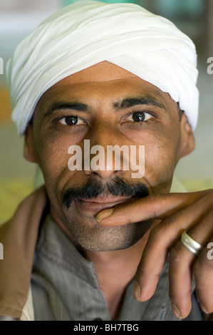 Portrait of a young Arab Muslim Egyptian man wearing a headscarf, in a contemplative pose, in the Saharan town of Dakhla Oasis, Western Desert, Egypt. Stock Photo