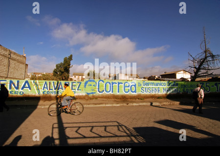 Ecuador, Saquisili, man on his bike cycling by a wall painted for the municipal elections campaign Stock Photo