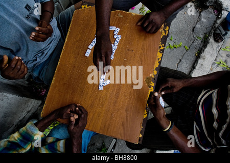 Haitian men play dominoes on the street close to the La Saline market ...