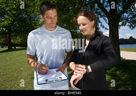 A woman with a personal trainer taking notes Stock Photo