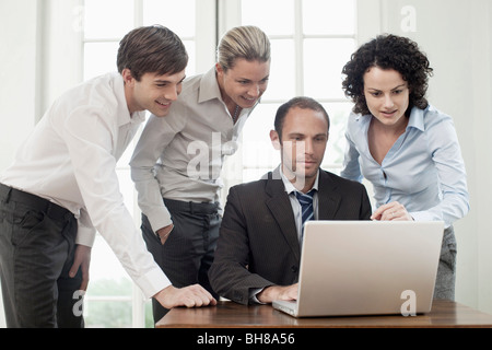 Business colleagues gathered around a laptop Stock Photo