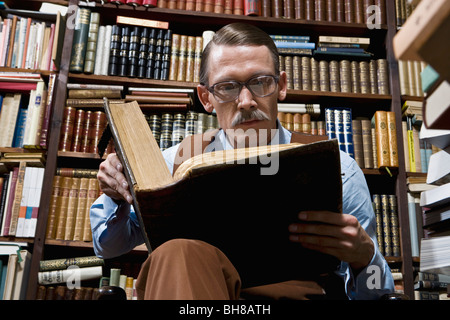 A man reading a book in a bookstore Stock Photo