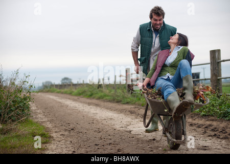 man pushing woman in wheelbarrow Stock Photo