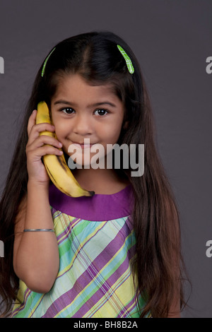 Girl using a banana as a phone Stock Photo