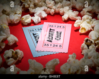 Close up shot of two generic admission tickets surrounded by popcorns. Stock Photo