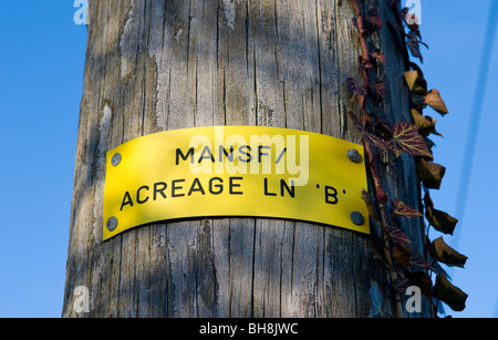 Plastic notice nailed to a wooden pole indicating the 33kV line B over high voltage supply at Acreage lane, Mansfield, England. Stock Photo