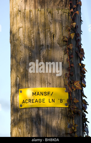 Plastic notice nailed to a wooden pole indicating the 33kV line B over high voltage supply at Acreage lane, Mansfield, England. Stock Photo