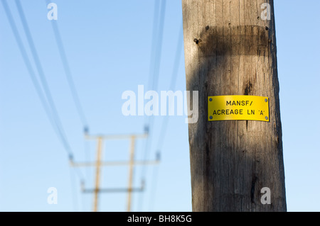 Plastic notice nailed to a wooden pole indicating the 33kV line A over high voltage supply at Acreage lane, Mansfield, England. Stock Photo