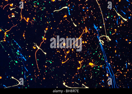 Stock photo of abstract day glo paint splatters against black background. Stock Photo