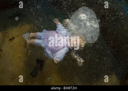 Doll trapped under ice Stock Photo