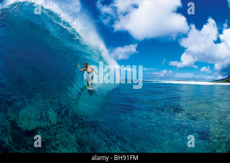 Surfer in the tube of large wave on a reef break in the Cook Islands Stock Photo