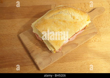 Cuban sandwich with ham, cheese, and pickles on a wooden board. Stock Photo