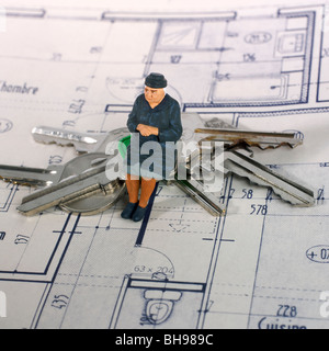 Elderly woman, figurine, and keys of apartments on a construction plan