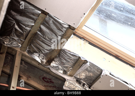 Installation of foil roof insulation in a domestic property Stock Photo ...