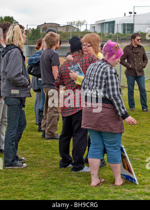 The mother of a young adult suicide is hugged by friends of her late daughter at an outdoor memorial service at a public park. Stock Photo