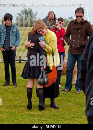 The mother of a young adult suicide is hugged by well-wishers at an outdoor memorial service in Laguna Beach, CA. Stock Photo