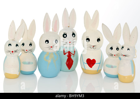 wooden easter bunnies in a row on a white reflecting background Stock Photo