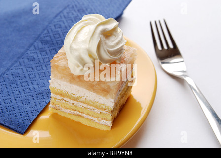 Apple dessert with whipped cream on yellow plate with dessert fork Stock Photo