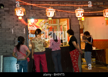 Beijing, CHINA- Old Traditional Hutong Neighborhood, Lit up at Night, Chinese Food Shop, late night food, shop window scene Stock Photo