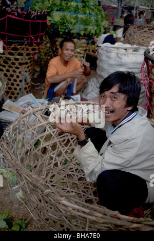 filipino market trader about to eat Balut a 15 day Duck embryo boiled and eaten in the Philippines as a popular street food Stock Photo