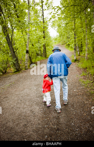 Grandfather and granddaughter walking on path, Thunderbird Falls, Chugach State Park, Alaska Stock Photo