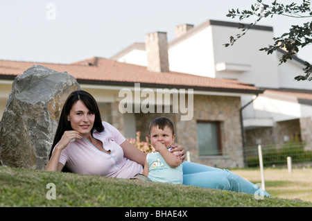 Young woman in garden with baby boy Stock Photo