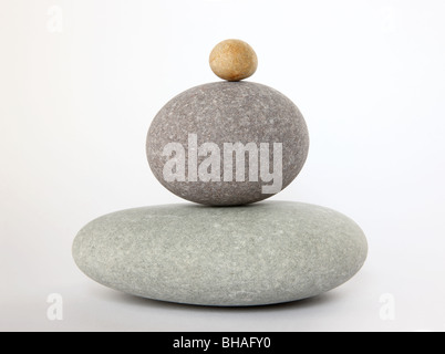 Three rounded pebbles stacked on top of each other with a large one at the bottom and small on on top Stock Photo