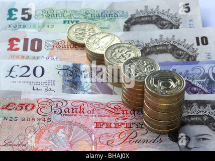 Five stacks of one pound coins in increasing size from one pound to nine pound coins. Five, ten, twenty pounds in background. Stock Photo