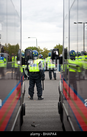 Anti riot police officers standing near police vans Stock Photo