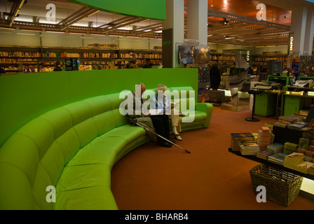 Senior couple reading in bookshop at Fünf Höfe shopping arcade Munich Bavaria Germany Europe Stock Photo