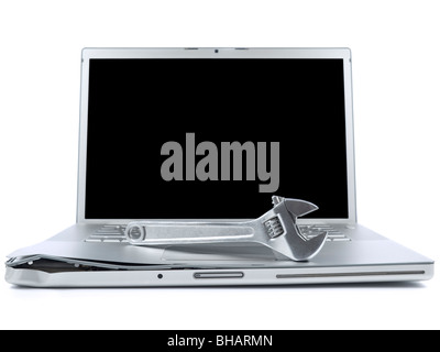 A spanner over a damaged laptop isolated over white background. Black copy space on screen. Stock Photo