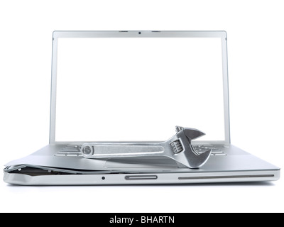 A spanner over a damaged laptop isolated over white background. Black copy space on screen. Stock Photo