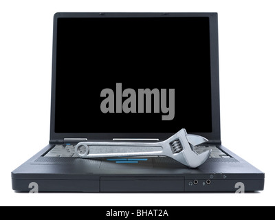 A spanner over a black laptop isolated over white background. Black copy space on screen. Stock Photo