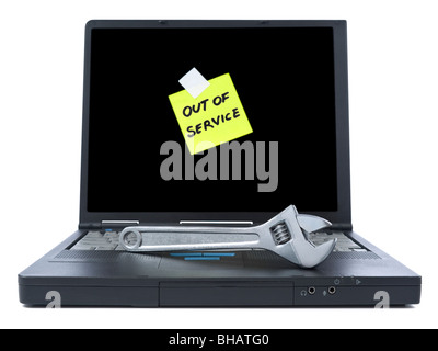 Laptop with an Out of Service sticky note and a spanner over the keyboard. Isolated on white. Stock Photo