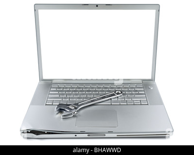 A spanner over a damaged laptop isolated over white background. White copy space on screen. Stock Photo